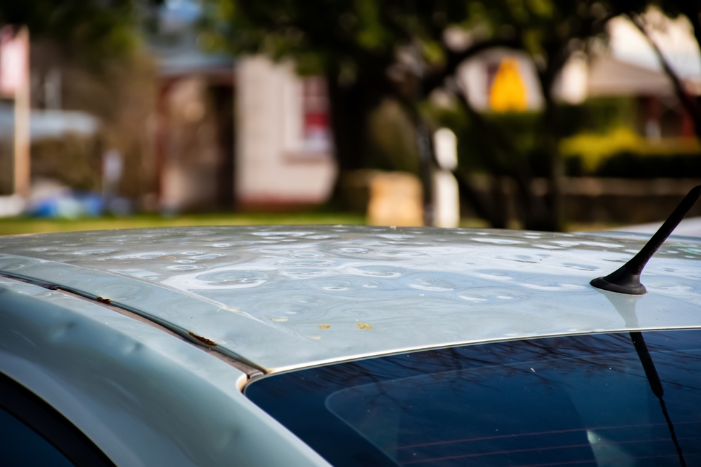 Car,roof,damaged,by,major,hailstorm,hailstones.,car,insurance,repair